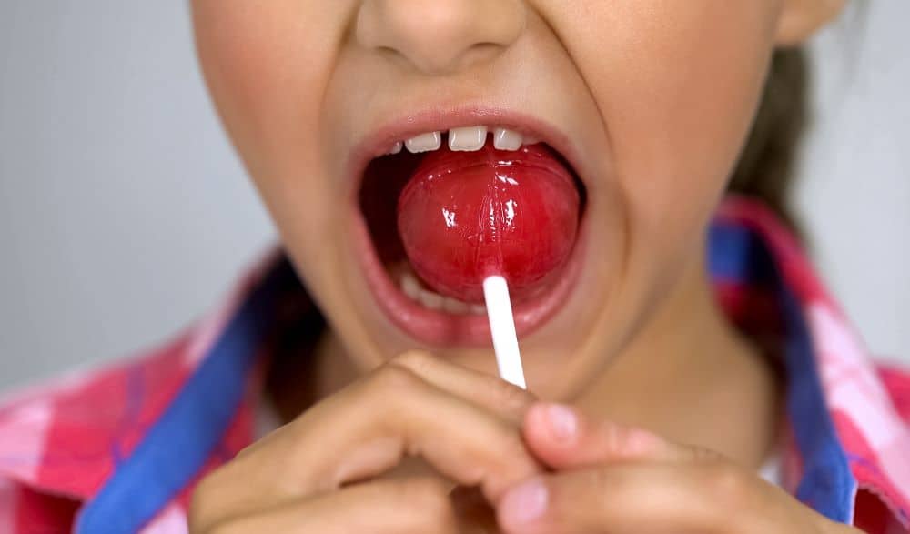 Child eating lollipop.