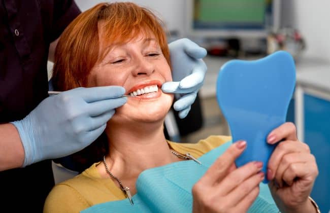 Senior woman having dentures checked.