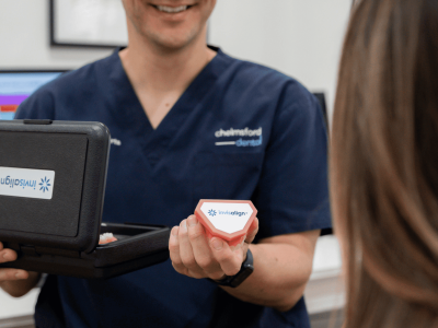 Dentist at Chelmsford Dental Mount Lawley handing an Invisalign box to a patient