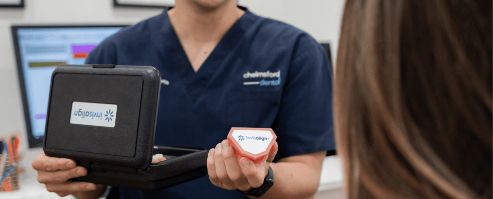 Dentist at Chelmsford Dental Mount Lawley handing an Invisalign box to a patient