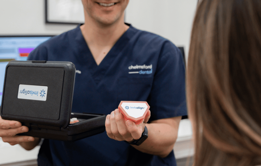 Dentist at Chelmsford Dental Mount Lawley handing an Invisalign box to a patient