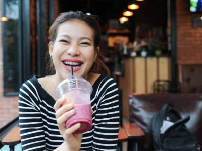 lady with braces drinking a drink