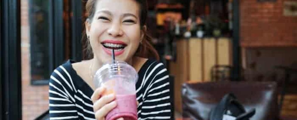 lady with braces drinking a drink