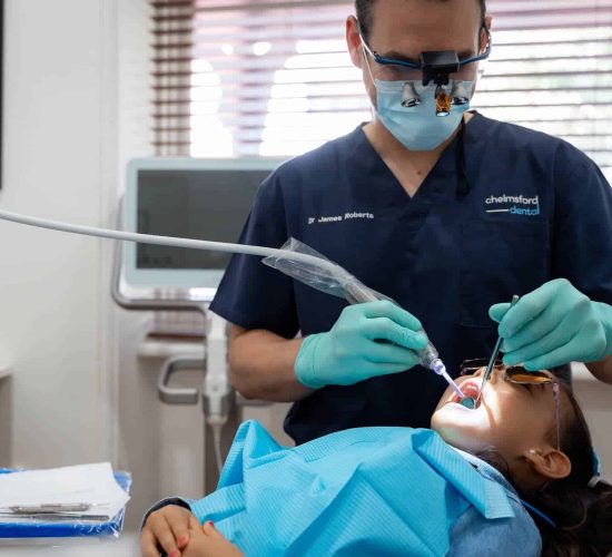 dentist cleaning child teeth at dental clinic