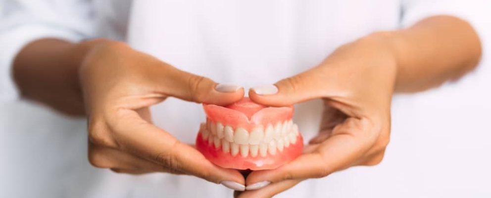 Dentist holding dentures.