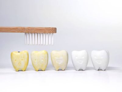 a tooth brush over the top of cartoon stained yellow teeth