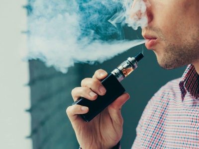 Close up on a man exhaling vape