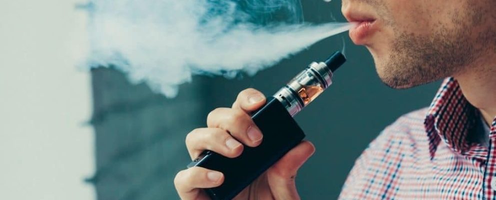 Close up on a man exhaling vape