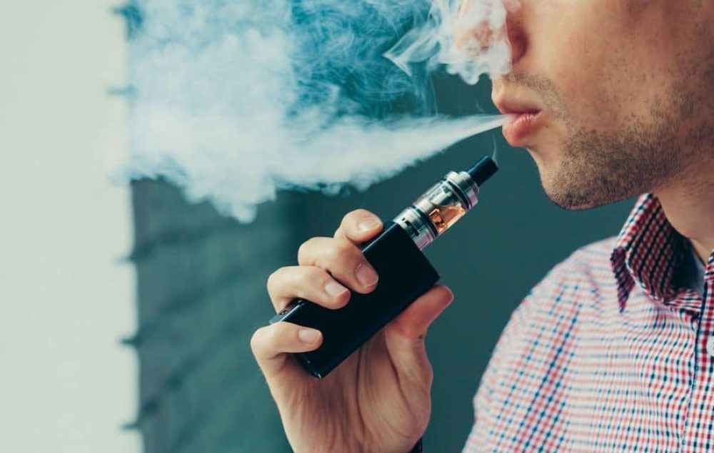 Close up on a man exhaling vape