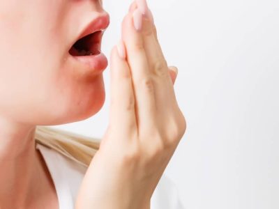 lady checking her breath by breathing into her hand