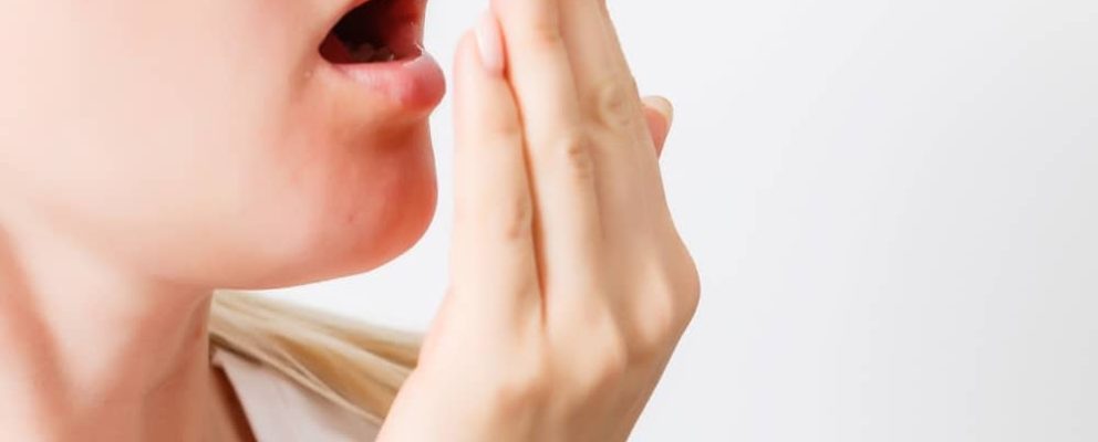 lady checking her breath by breathing into her hand