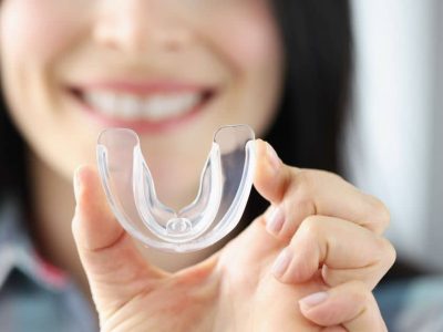 Woman holding mouthguard.