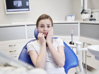 Terrified woman at dental clinic.