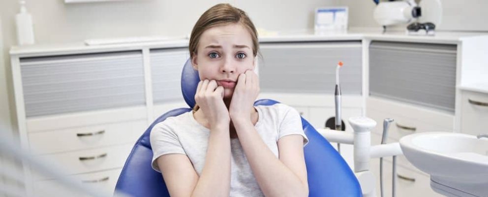 Terrified woman at dental clinic.