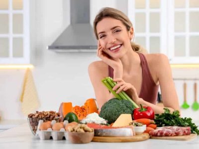 lady with a group of healthy foods that are good for oral hygiene