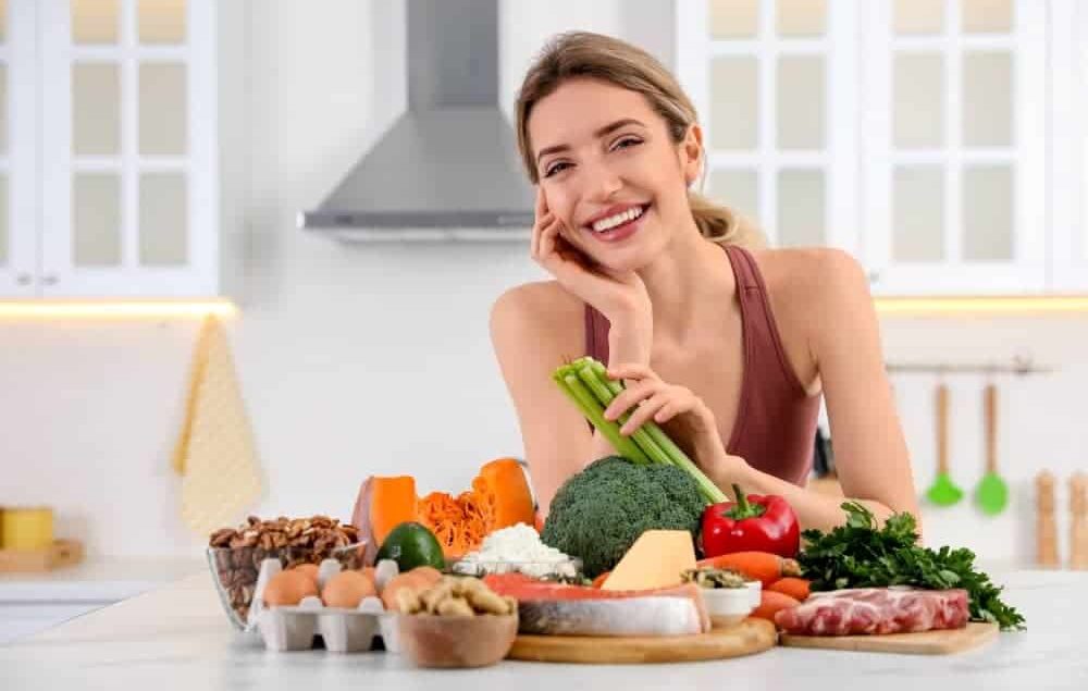 lady with a group of healthy foods that are good for oral hygiene